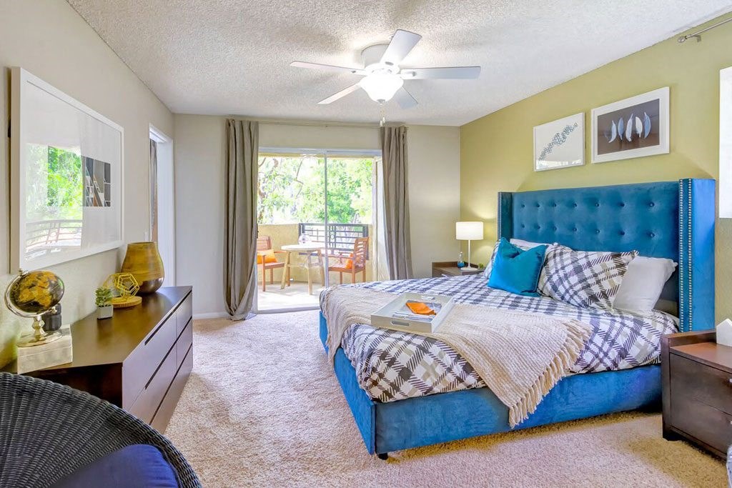 a bedroom with a bed and a ceiling fan