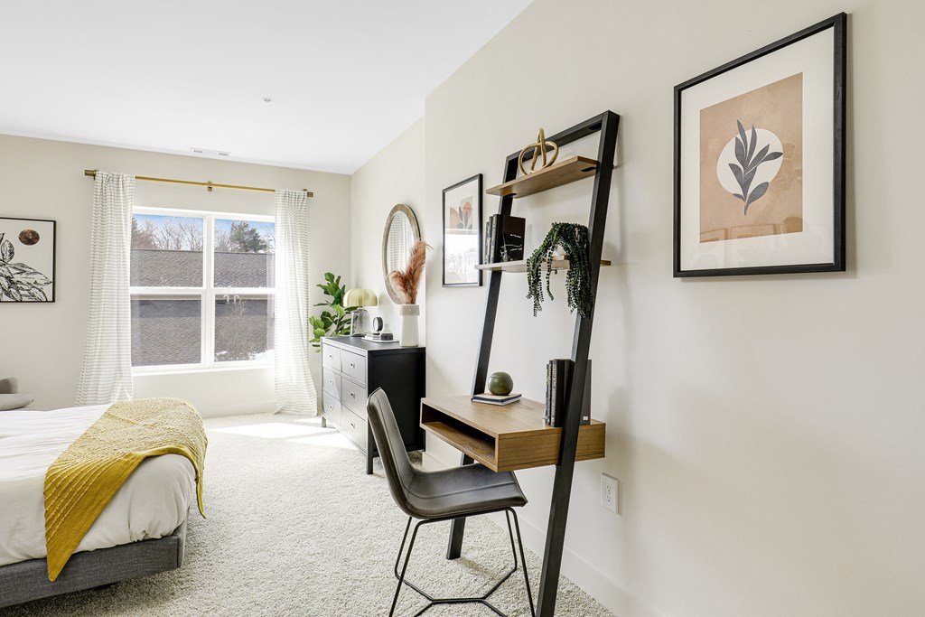 a bedroom with a bed and a desk and a mirror