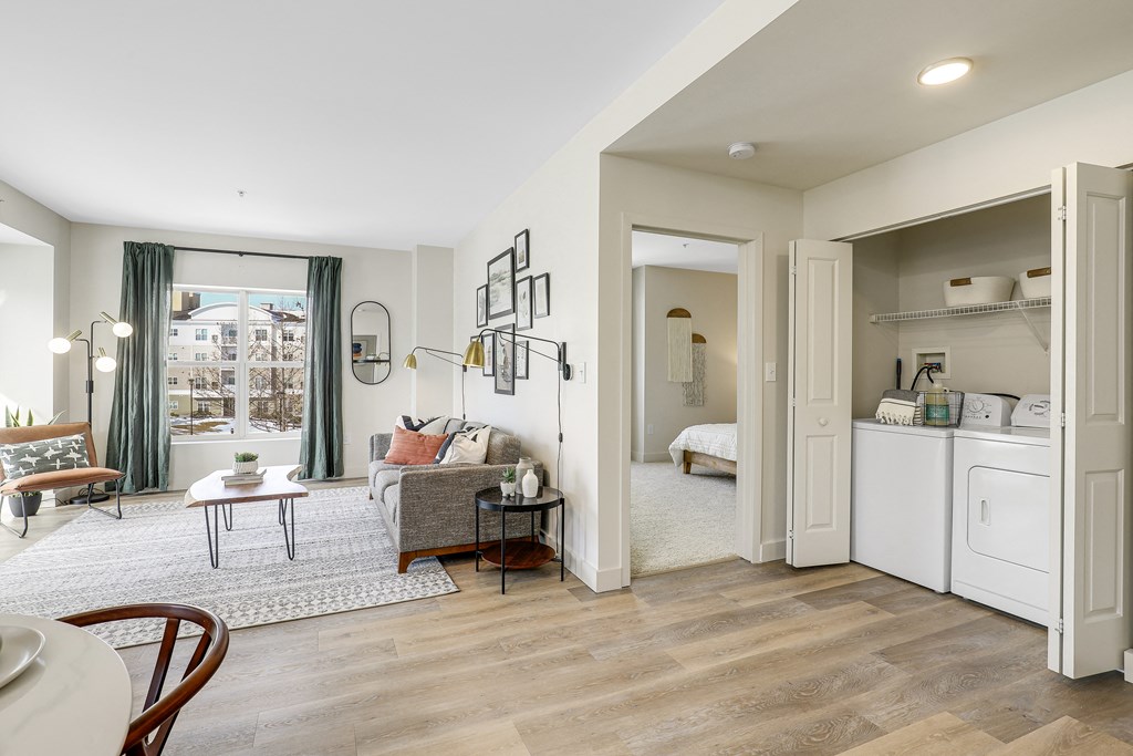 a living room with a couch and a table     and a kitchen