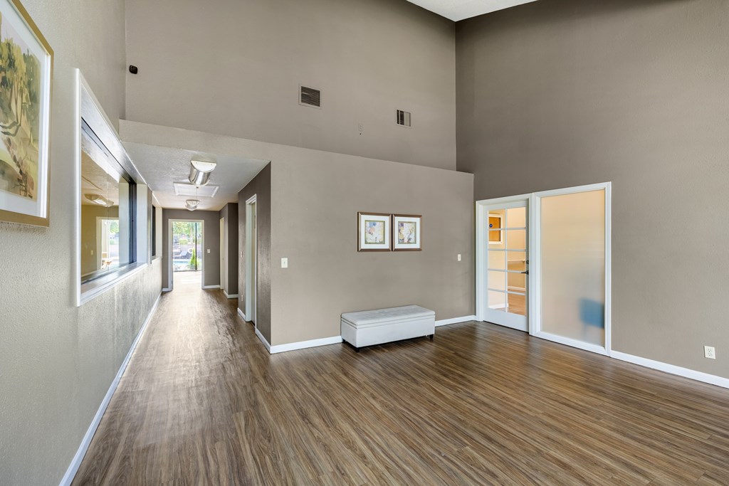A long hallway with a bench and pictures on the wall.
