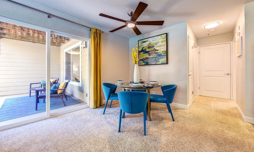 a dining room with a table and chairs and a ceiling fan