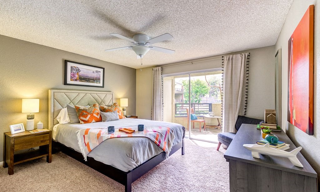 a bedroom with a bed and a ceiling fan