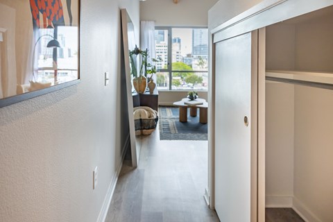 A hallway with a mirror on the wall and a door on the right.