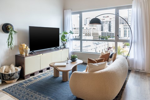A living room with a large window overlooking a cityscape.