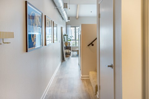 A hallway with a series of framed pictures on the wall.