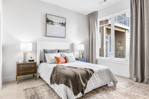 A bedroom with a large bed and a painting on the wall.