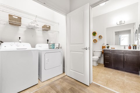 A white bathroom with a white door and a white sink.