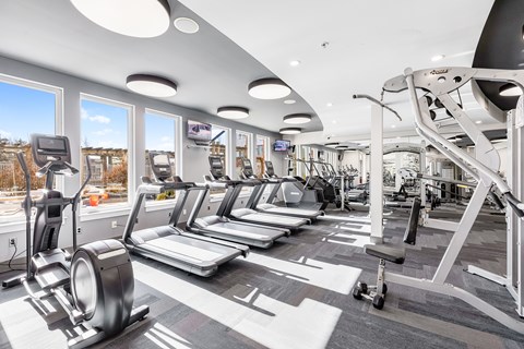 A gym with treadmills, elliptical machines, and other exercise equipment.