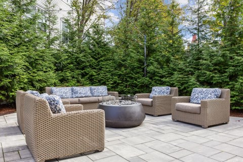 A patio with wicker furniture and a fire pit.
