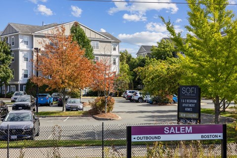 A sign for Salem Outbound Boston is in front of a parking lot.