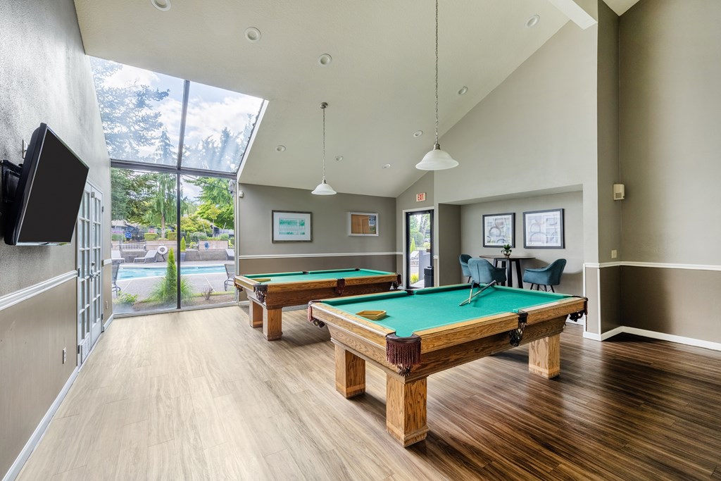 A room with a pool table and a television.