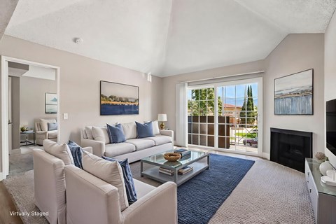 A living room with a fireplace and a view of the backyard.