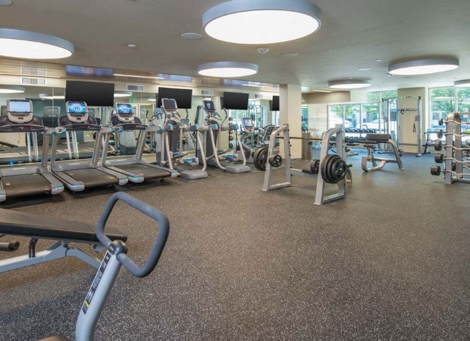 a gym with cardio machines and weights on the floor