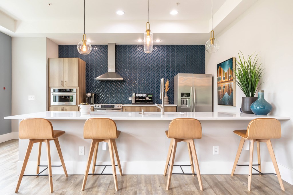 a kitchen with bar stools in front of a counter top