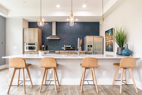 a kitchen with bar stools in front of a counter top