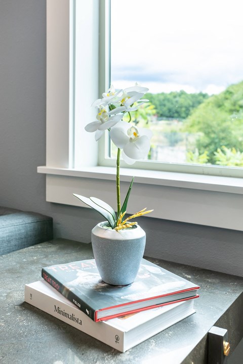 a vase with flowers on a table next to a window