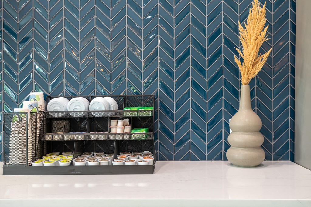 a vase of wheat on a counter in a room with blue chevrons