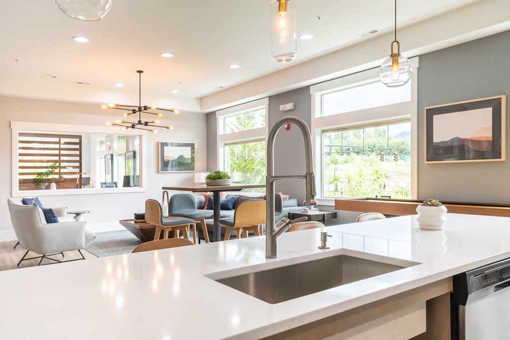 an open kitchen and living room with a sink and a counter top