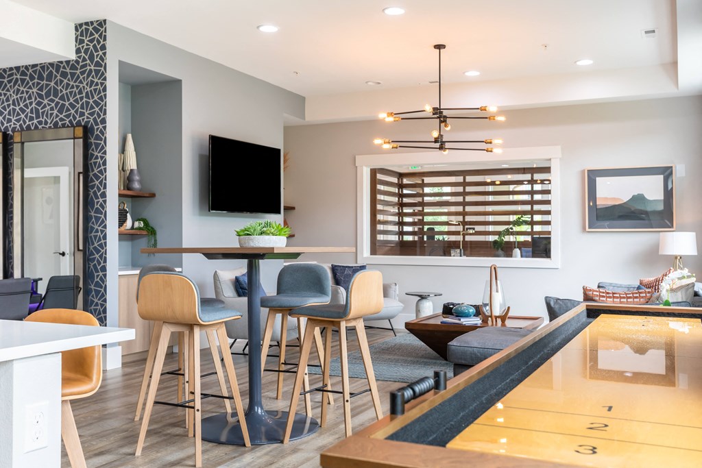a living room with a bar and a kitchen with stools