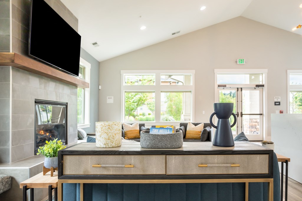 a living room with a fireplace and a table with a couch and a television