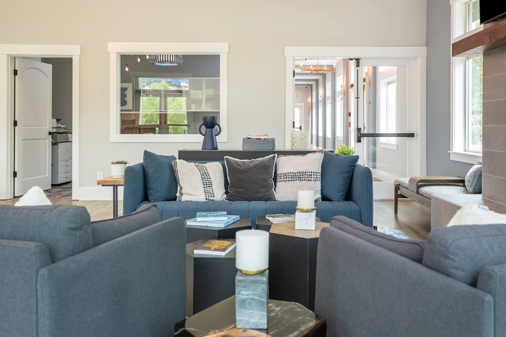 a living room with blue couches and a table with candles