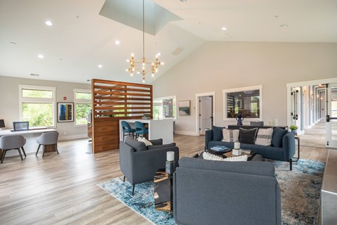 a living room with blue couches and chairs and a dining room and a kitchen