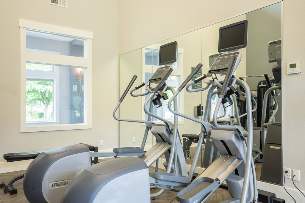 a gym with various machines and mirrors in a treatment room