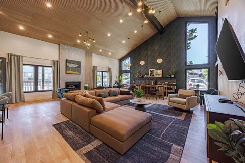 A living room with a brown sofa and a wooden floor.