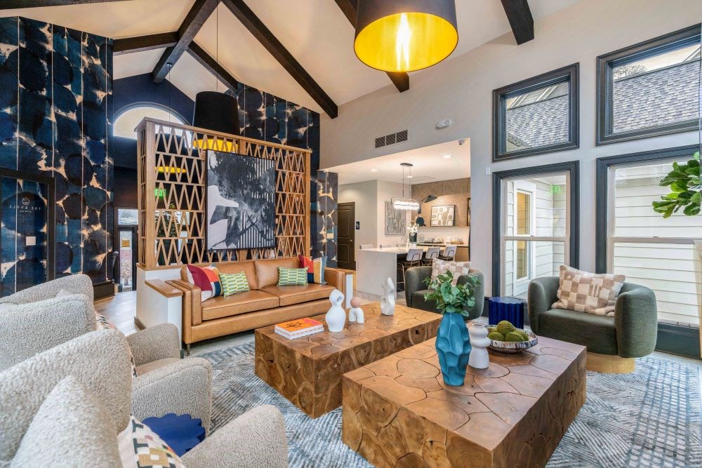 A living room with a large wooden coffee table and a grey sofa.