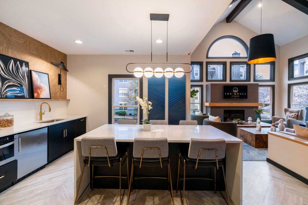 A modern kitchen with a large island and bar stools.