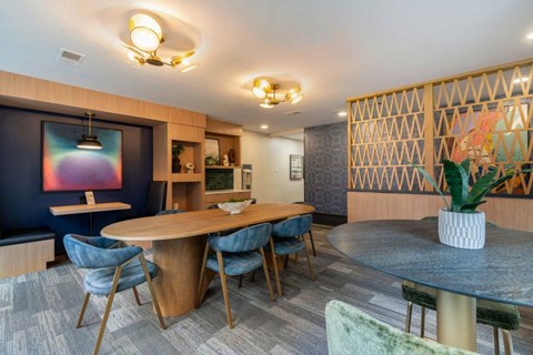A modern dining room with a wooden table and blue chairs.