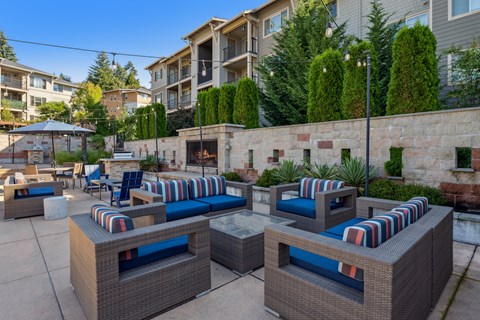 an outdoor patio with couches and chairs and a fire pit