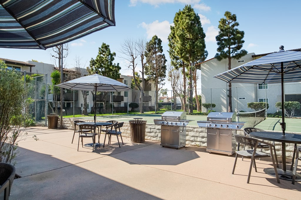 A patio with a table and chairs under a striped umbrella.