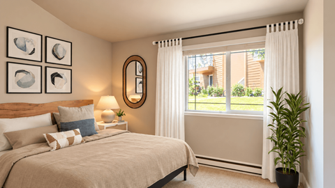 A bedroom with a large bed and a window with curtains.