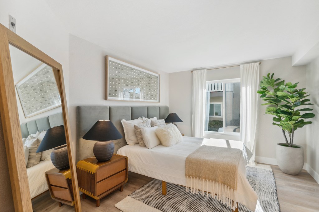 a bedroom with a large bed and a mirror