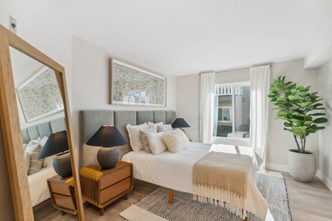 a bedroom with a large bed and a mirror