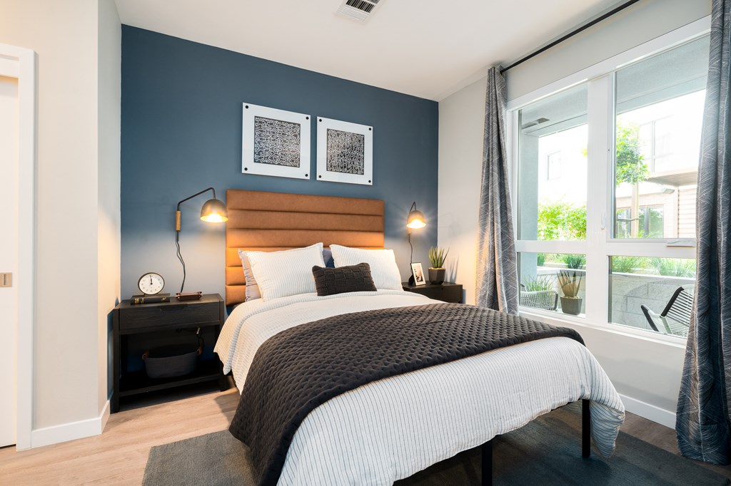 a bedroom with a bed and a large window