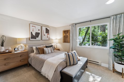 a bedroom with a bed and a large window