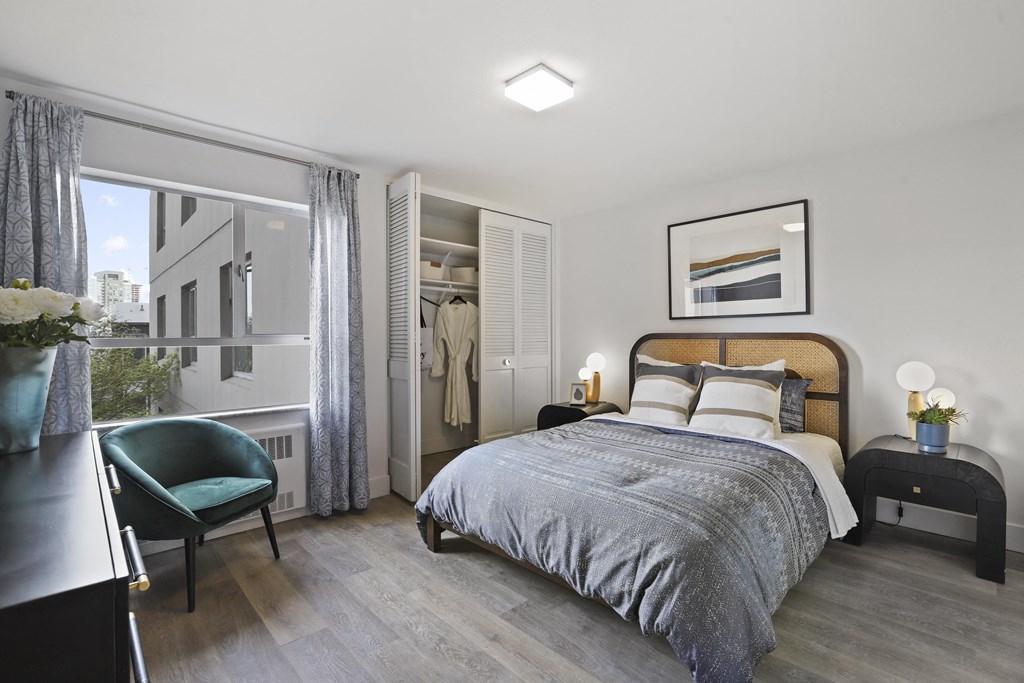 a bedroom with a bed and a chair and a window