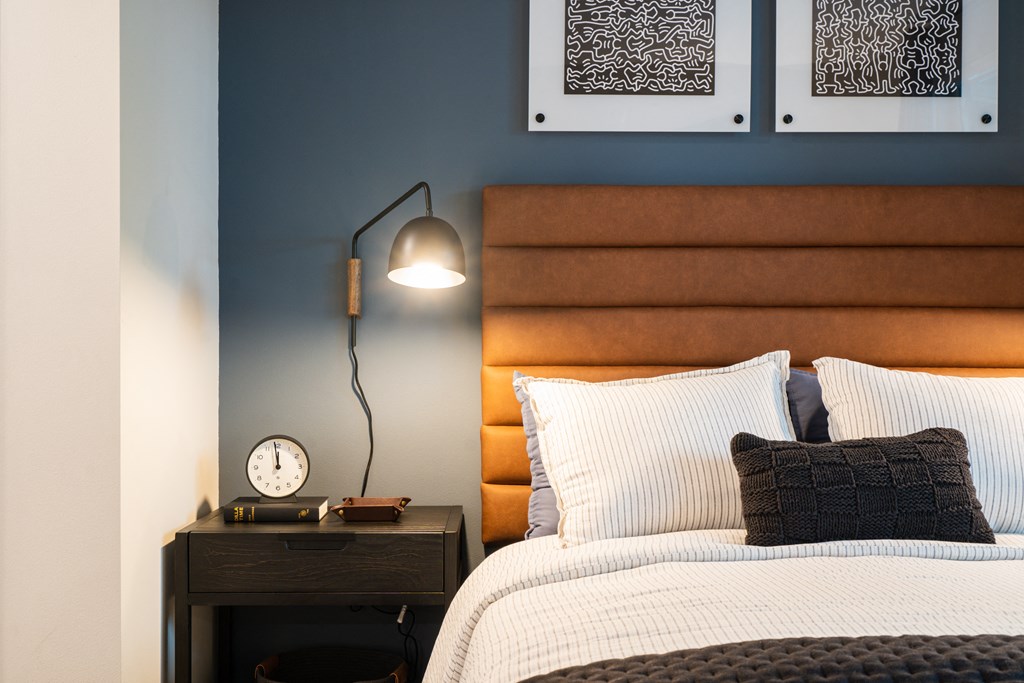 a bedroom with a bed and a clock on a night stand