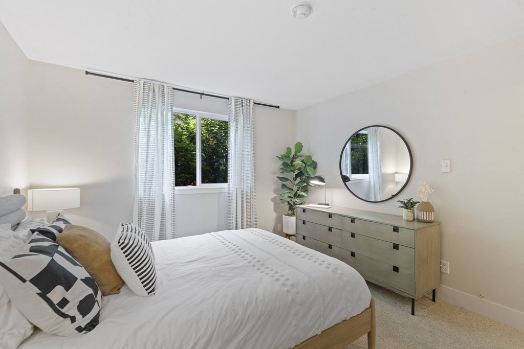 a bedroom with a bed and a dresser with a mirror