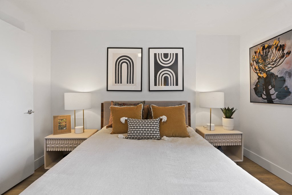 a bedroom with a large bed and two paintings on the wall