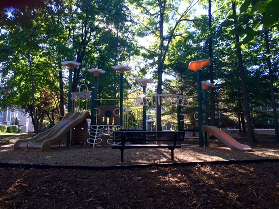a playground with slides and a bench in a park