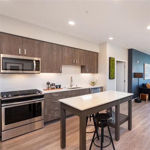 a kitchen with stainless steel appliances and a white table