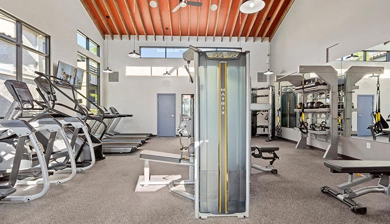 a gym with cardio equipment and weights in it