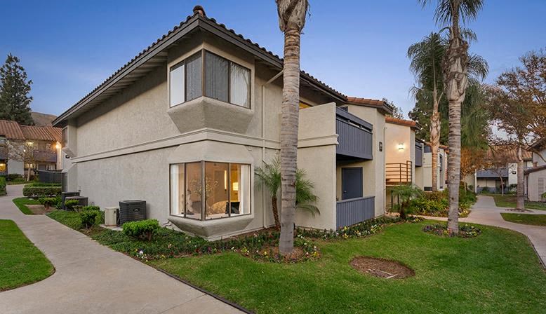 a house with a sidewalk and palm trees