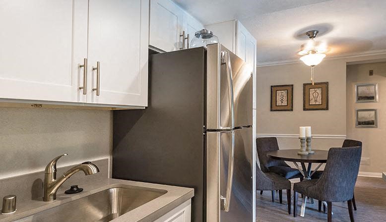a kitchen with a sink and a stainless steel refrigerator