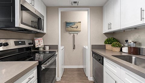 a kitchen with white cabinets and a black stove