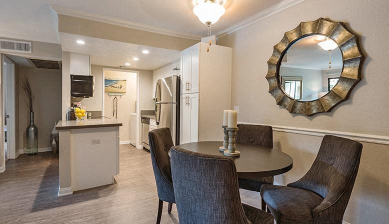 a dining room with a table and chairs and a mirror
