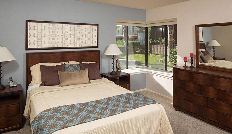 a bedroom with a bed and a large window